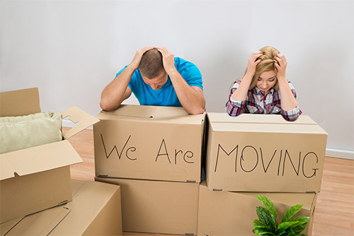 Couple in a stressful move packing boxes
